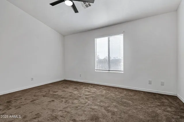 an empty room with fan and entrance