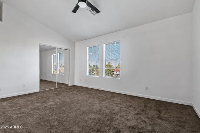 a view of a house with a large window and wooden fence