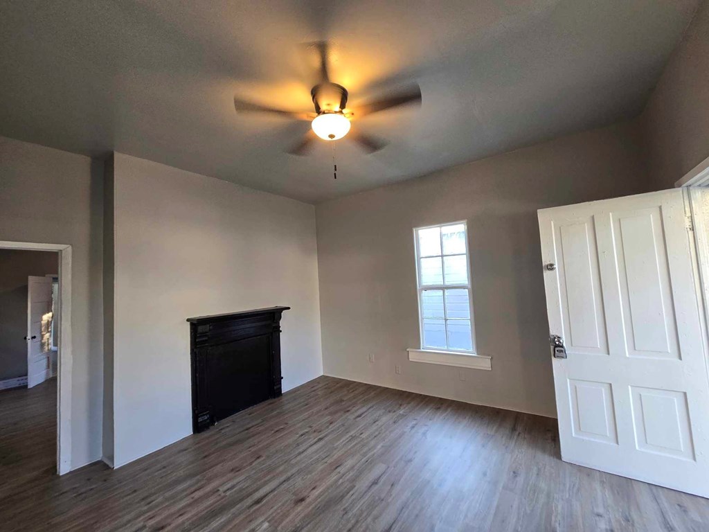 2808 9th Street Columbus, GA 31906 - Photo 3 of 8 an empty room with wooden floor cabinet and windows