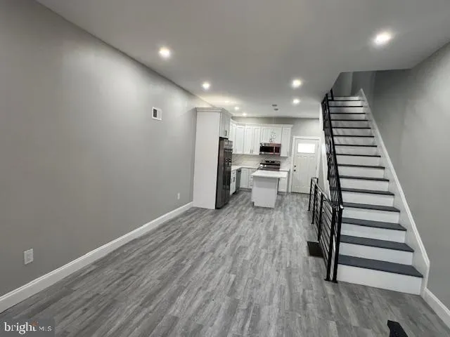 a view of a kitchen with wooden floor and stairs