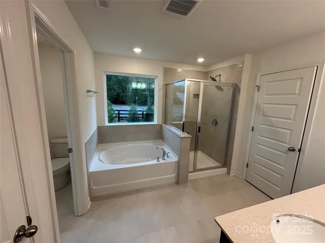 a bathroom with a tub a sink and a large window