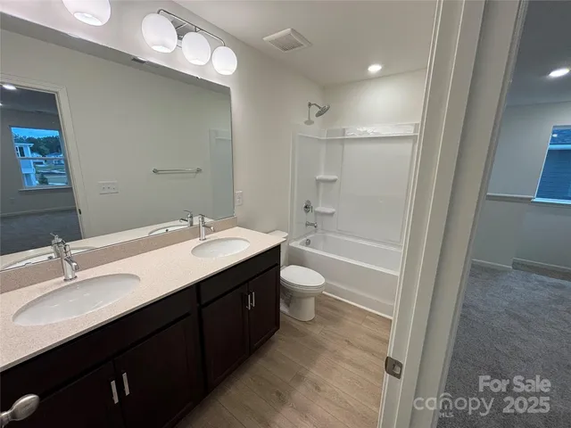a bathroom with a granite countertop sink a toilet and shower
