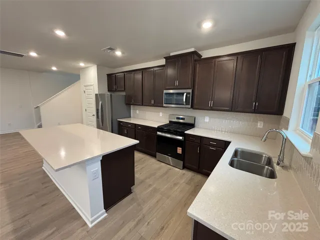a kitchen with stainless steel appliances wooden cabinets sink and stove