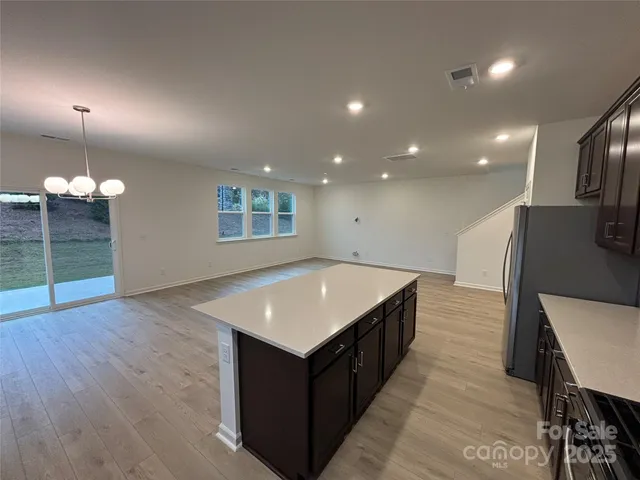 a kitchen that has a sink a table and chairs in it