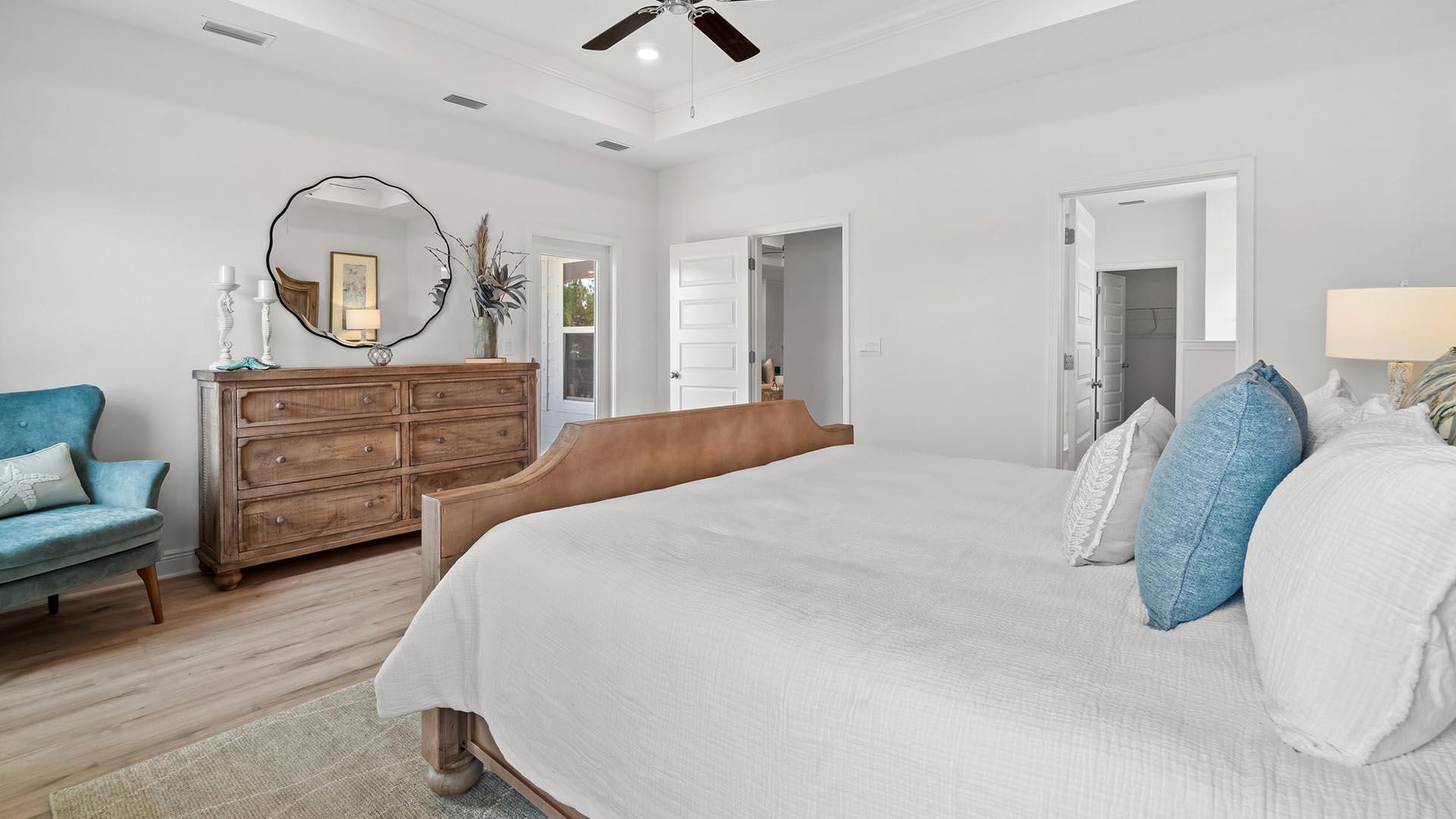9 Blue Bell Circle Santa Rosa Beach, FL 32459 - Photo 16 of 32 a bedroom with a bed a mirror on dresser and a chandelier