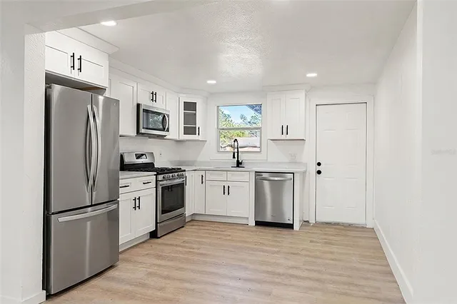 a kitchen with stainless steel appliances a refrigerator sink and cabinets