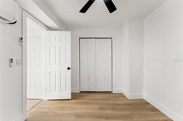 a view of an empty room with wooden floor and entryway