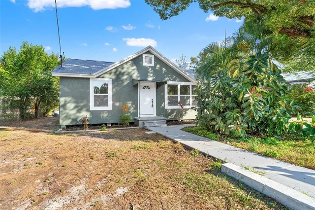 a view of a house with a yard and potted plants