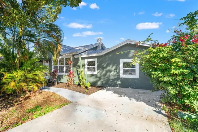a view of a house with a small yard and potted plants