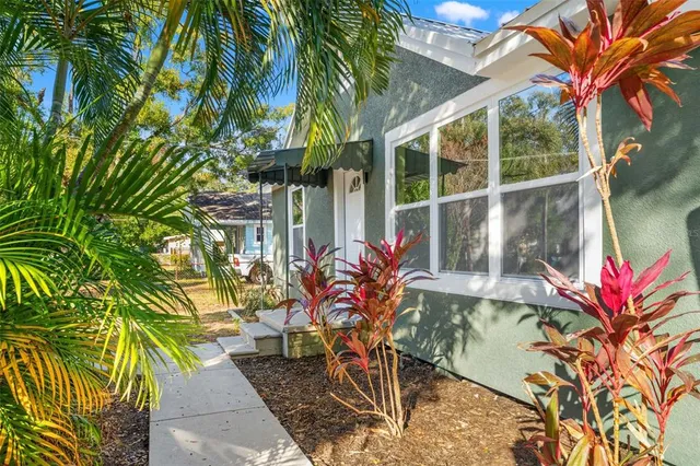a backyard of a house with table and chairs a barbeque and a potted plant