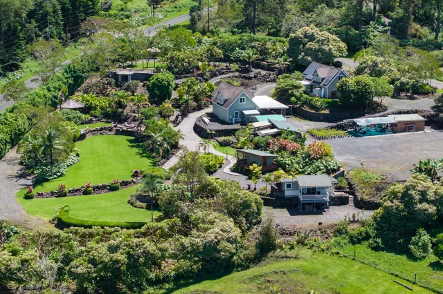 an aerial view of green house with a yard and outdoor seating