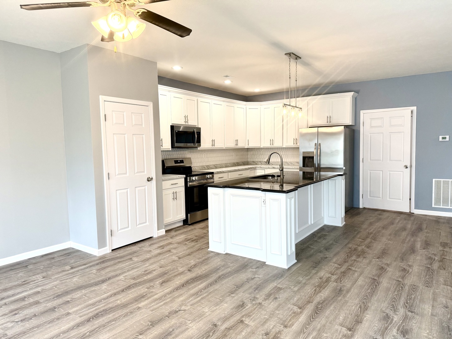 1104 Midway Court Marion, IL 62959 - Photo 3 of 13 a kitchen with stainless steel appliances kitchen island granite countertop a stove top oven a sink a refrigerator white cabinets and wooden floor