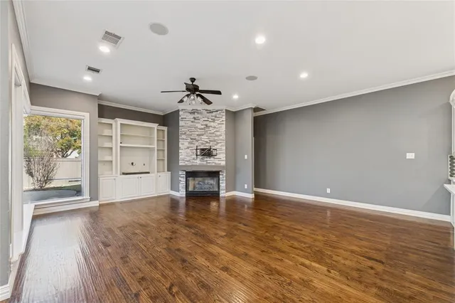 a large kitchen with white cabinets and wooden floor