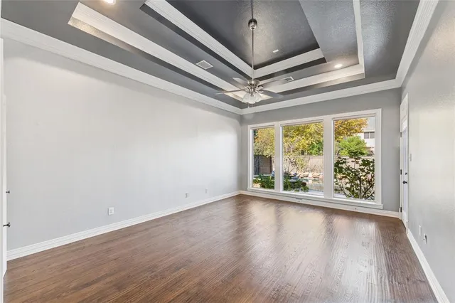 an empty room with a window and a ceiling fan