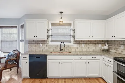a kitchen with granite countertop a sink stainless steel appliances and cabinets