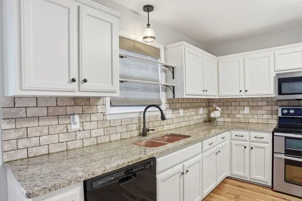 a kitchen with stainless steel appliances granite countertop a sink stove and cabinets