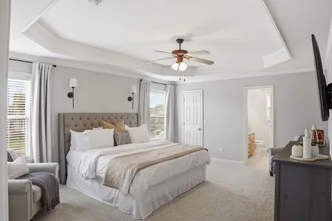 a bedroom with a large bed and a chandelier