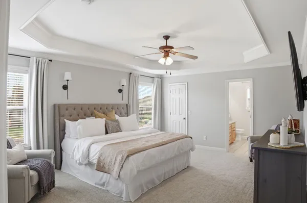 a bedroom with a large bed and a chandelier
