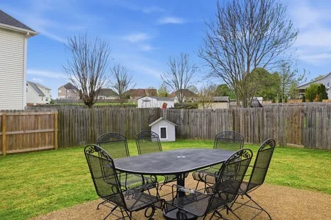 a view of a chairs and table in backyard of the house