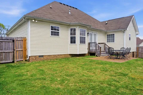 a view of a house with backyard and sitting area