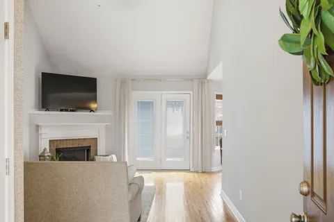 a living room with a fireplace a flat screen tv and a window