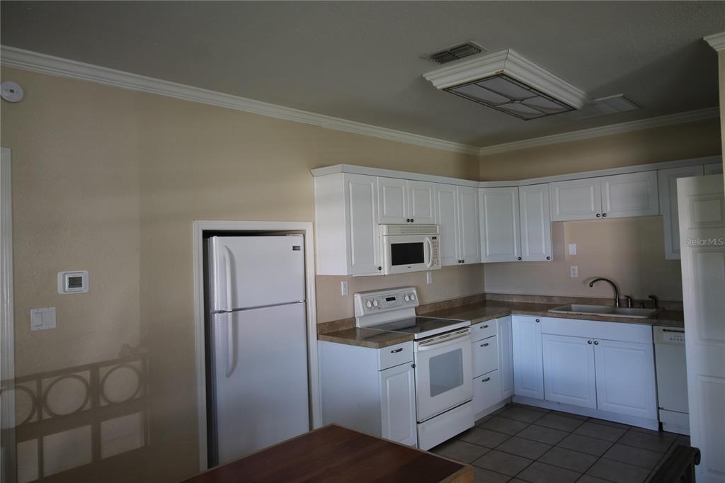 4820 Lake Gibson Park Road, Unit 3 Lakeland, FL 33809 - Photo 6 of 13 a kitchen with a sink a refrigerator and cabinets