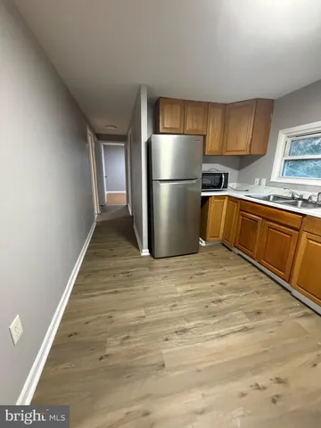 a kitchen with granite countertop a refrigerator and a sink