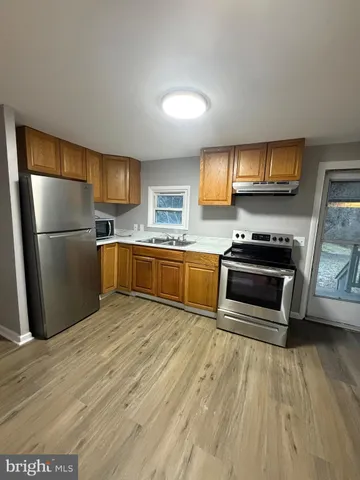 a kitchen with granite countertop a refrigerator and a stove top oven