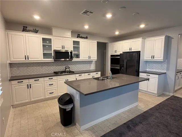 a large kitchen with stainless steel appliances granite countertop a sink a stove and a refrigerator