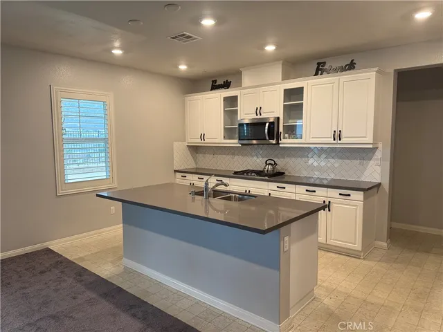 a kitchen with kitchen island granite countertop a sink stove and refrigerator