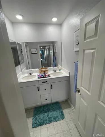 a bathroom with a double vanity sink mirror and toilet