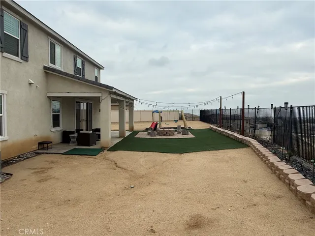 a view of a house with backyard and sitting area