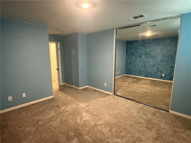 a view of a big room with closet and windows