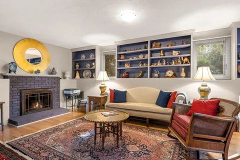 a living room with furniture a rug and a fireplace