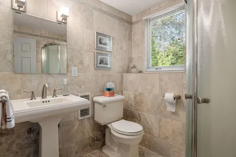 a bathroom with a sink toilet and a mirror