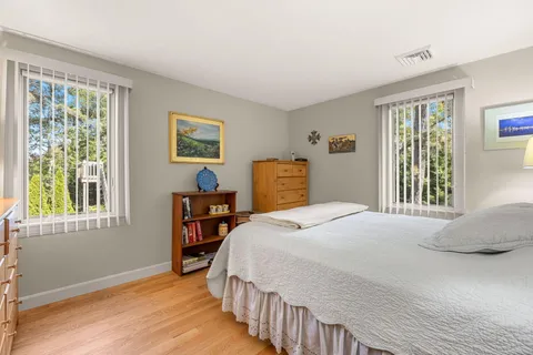 a bedroom with a bed dresser and a window
