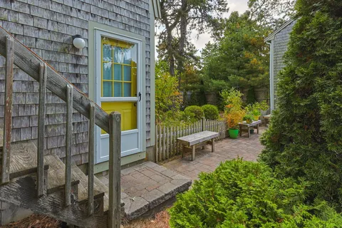 a view of a chairs and table under an umbrella in backyard