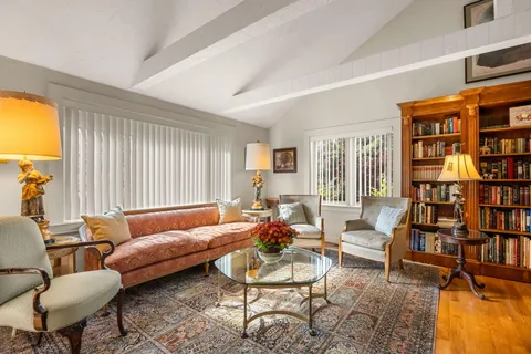 a living room with furniture and a book shelf