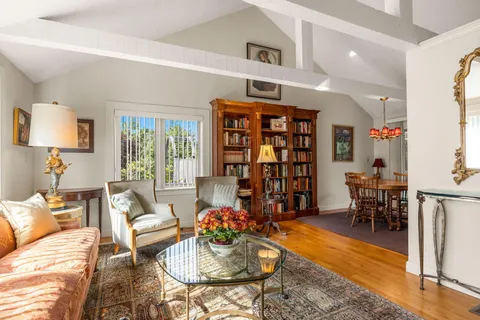 a living room with furniture a rug and a bookshelf