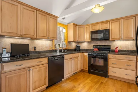 a kitchen with granite countertop a stove a sink and a microwave