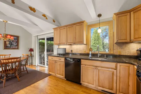a kitchen with stainless steel appliances granite countertop a stove a sink dishwasher and a refrigerator