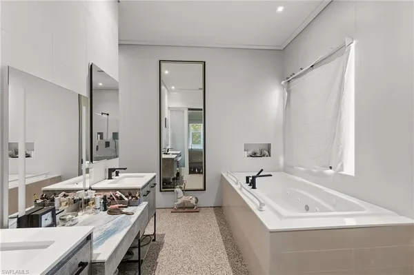 a bathroom with a tub a sink and a mirror