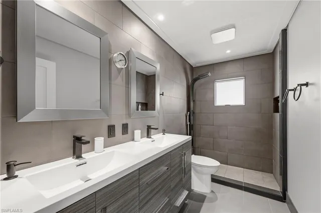 a bathroom with a double vanity sink toilet and shower