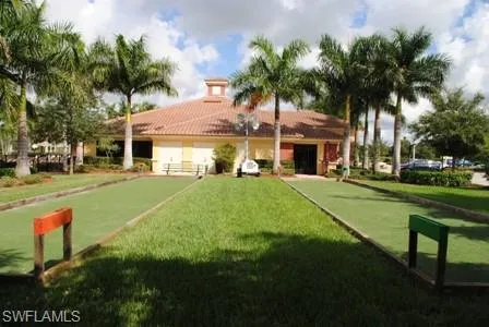 a front view of a house with garden and trees