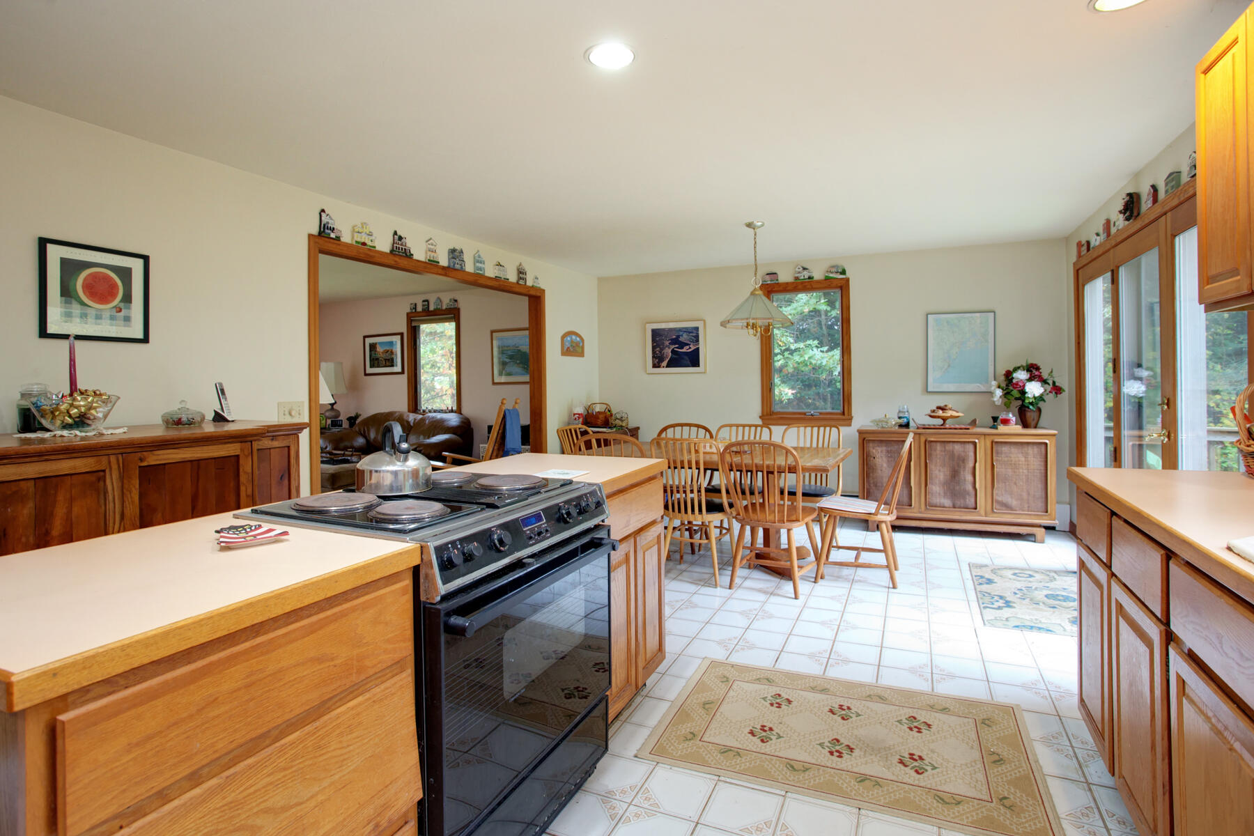 62 Pine Ridge Road Cotuit, MA 02635 - Photo 8 of 31 a open kitchen with stainless steel appliances granite countertop a stove top oven a dining table and chairs with the living room view