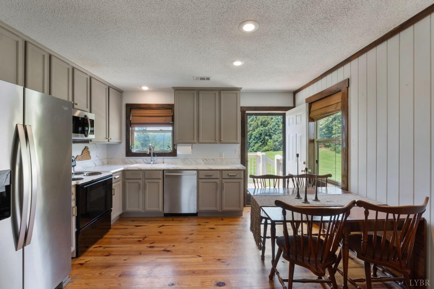 4466 Five Forks Road Pamplin, VA 23958 - Photo 9 of 34 a kitchen with stainless steel appliances granite countertop a table chairs sink refrigerator and cabinets