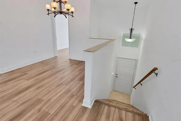a view of a room with wooden floor and ceiling fan