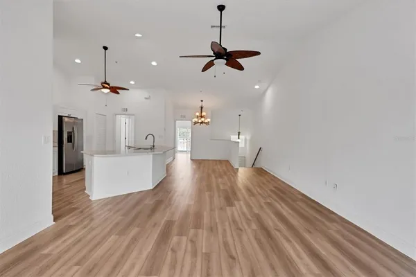 a kitchen with kitchen island stainless steel appliances a sink cabinets and wooden floor