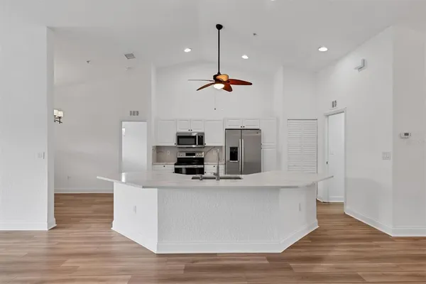 a kitchen with stainless steel appliances kitchen island a stove a sink and a refrigerator