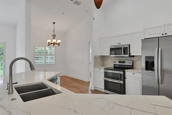 a kitchen with kitchen island a sink stainless steel appliances and cabinets